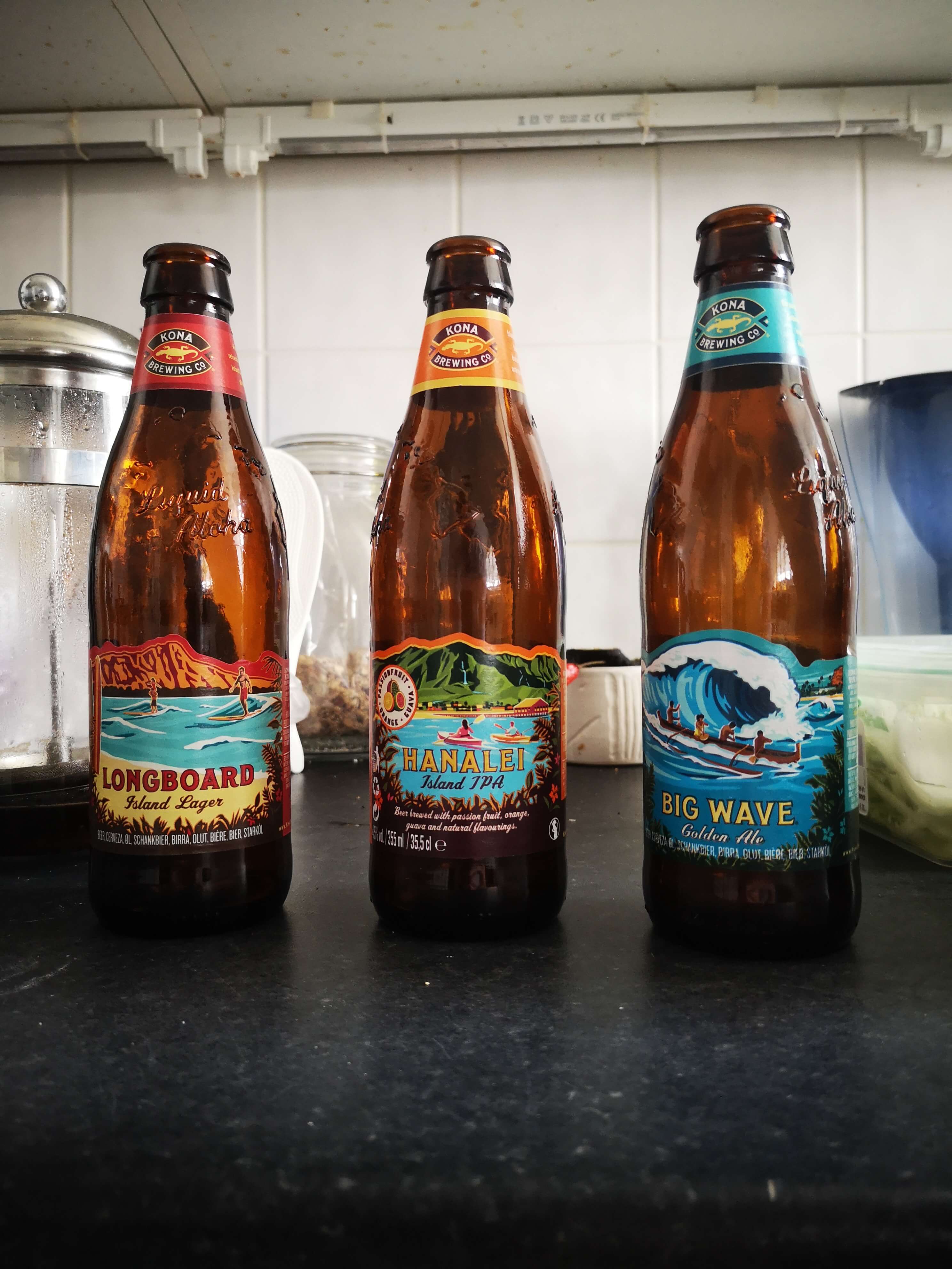 Kona Brewing Co beers, 3 bottles on my bench top from left to right L: Hanalei Island IPA. this articles review